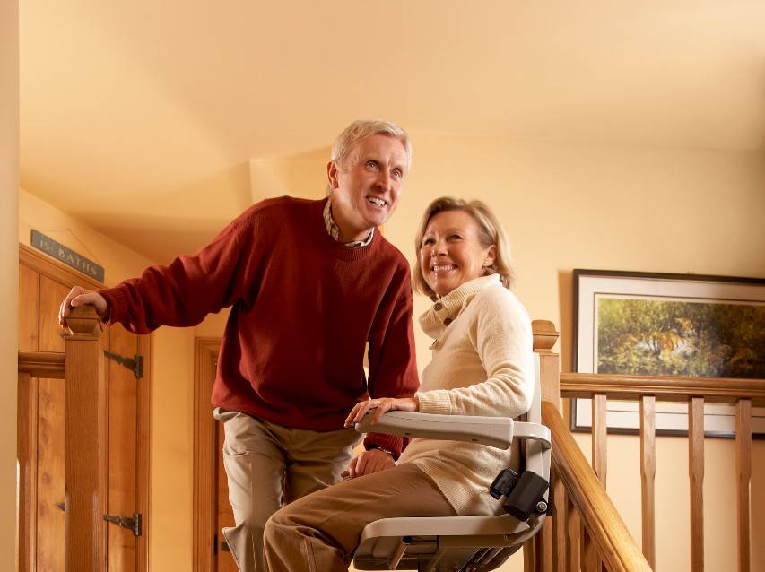 Couple de retraités avec femme assise sur un monte-escalier Prima Vital — photo originale