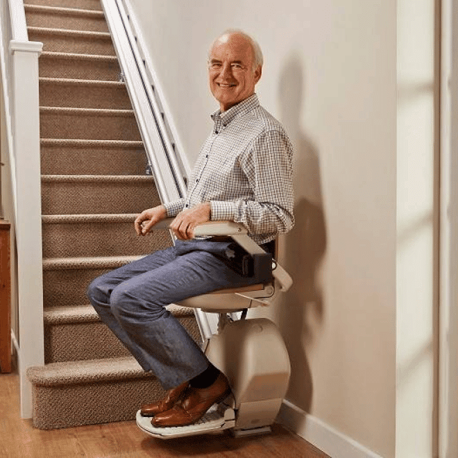Homme âgé installé dans fauteuil monte-escalier Prima Vital